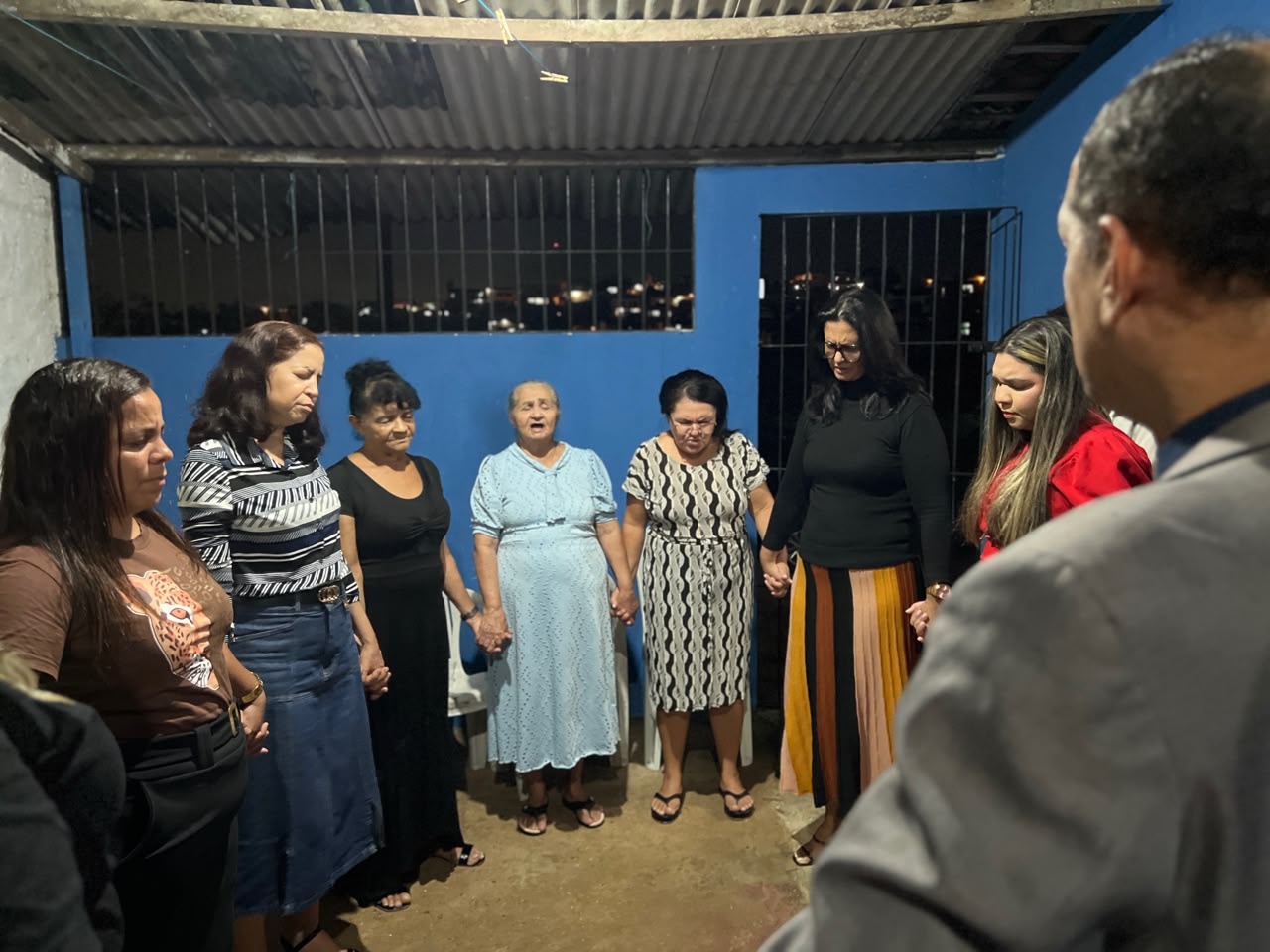Grupo de moradoras reunidas em frente a uma casa durante encontro